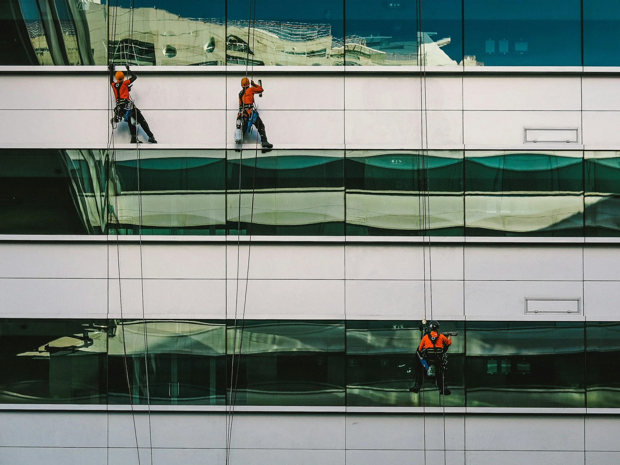 Maintenance workers on the glass facade of a building