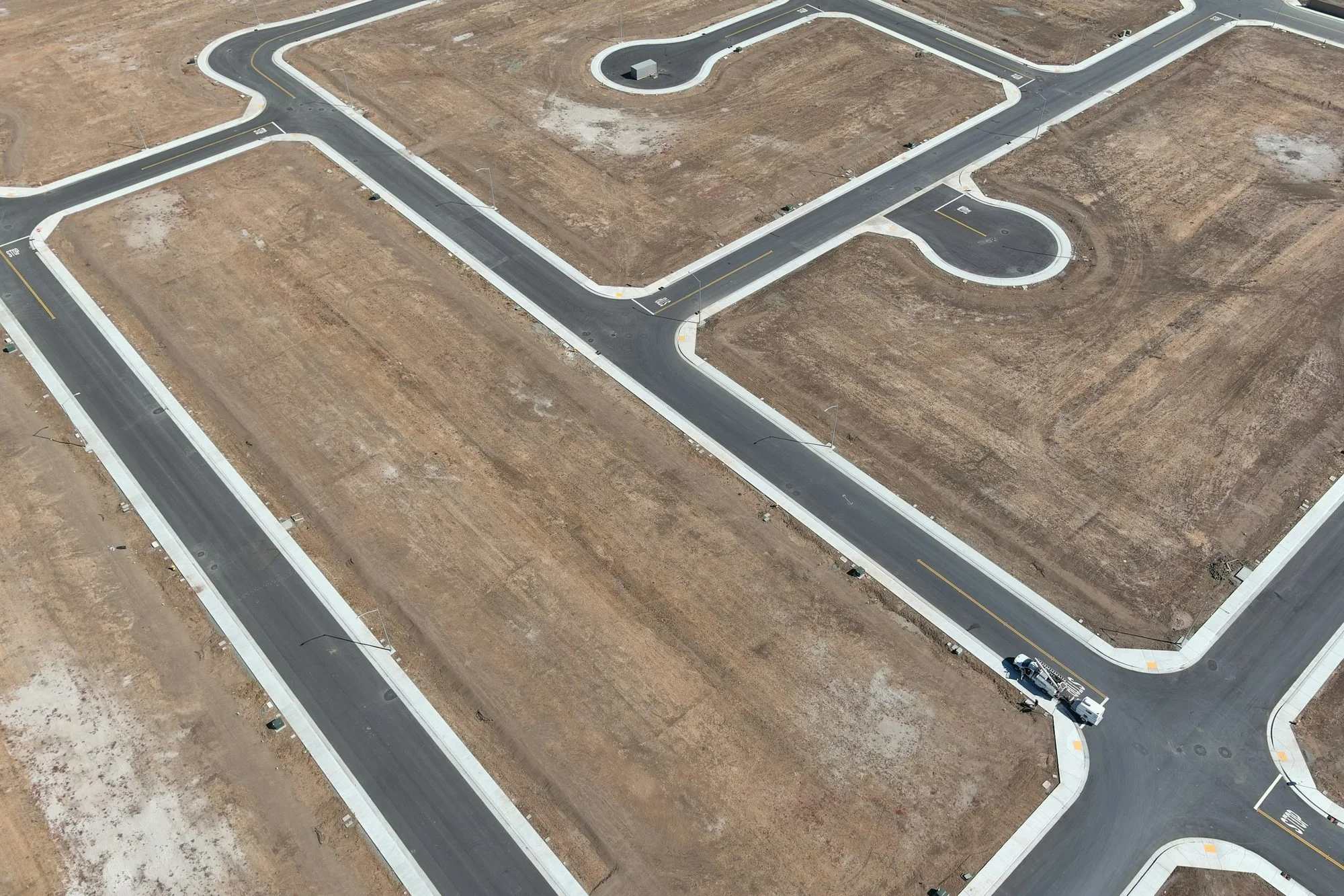 An aerial view of planned plots of land and paved roads